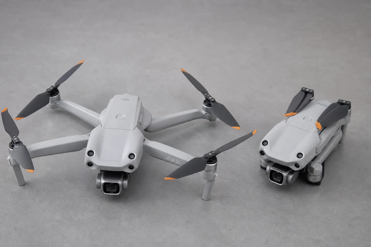 Five drones arranged on concrete surface showing different designs and sizes