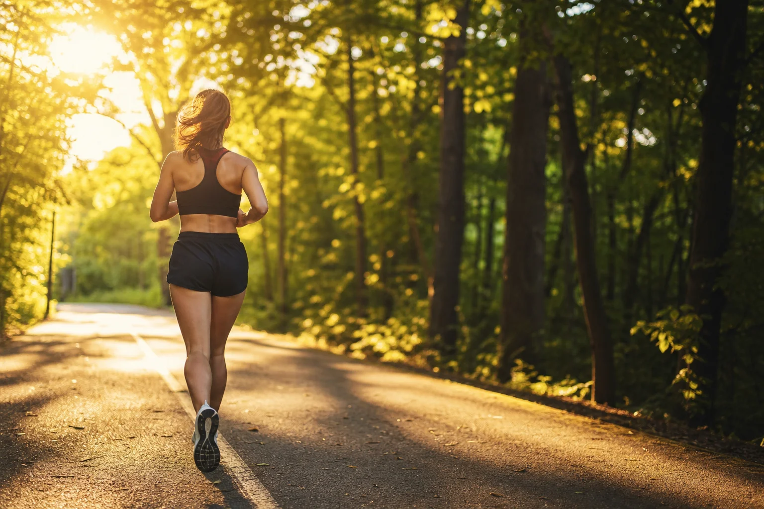 Runner jogging on tree-lined path with natural ambient light