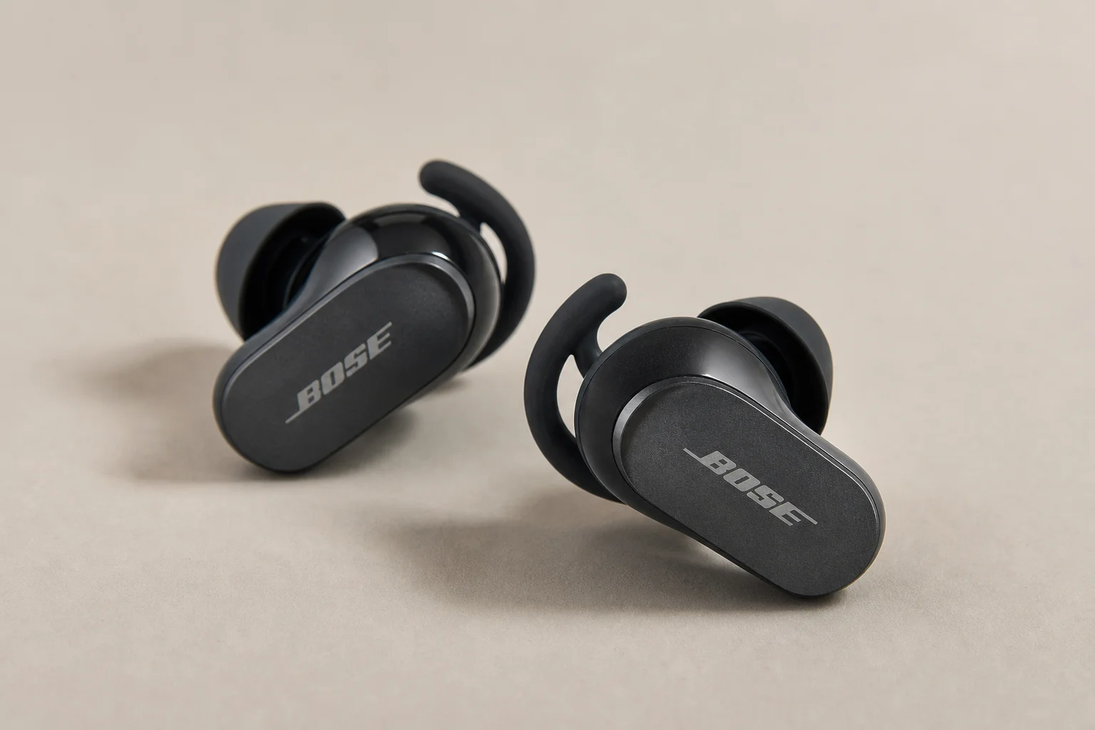 Collection of 12 true wireless earbuds arranged on concrete surface