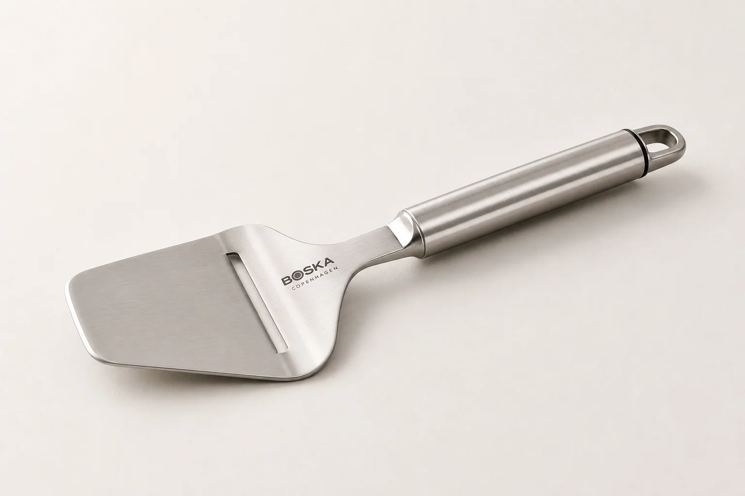 Five different cheese slicers arranged on a concrete surface