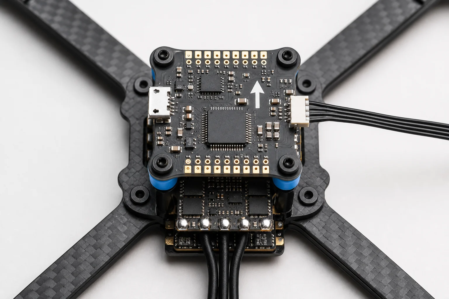 Flight controller mounted on dampers above ESC with arrow pointing forward