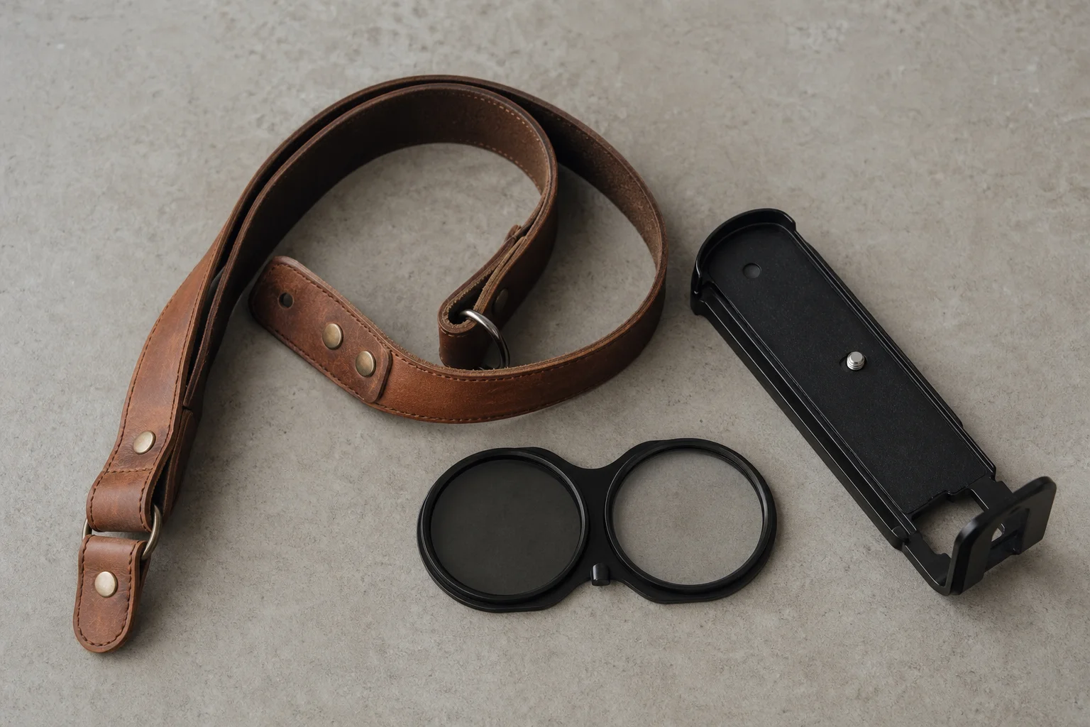 Overhead flat-lay of camera accessories on concrete surface including strap and filters
