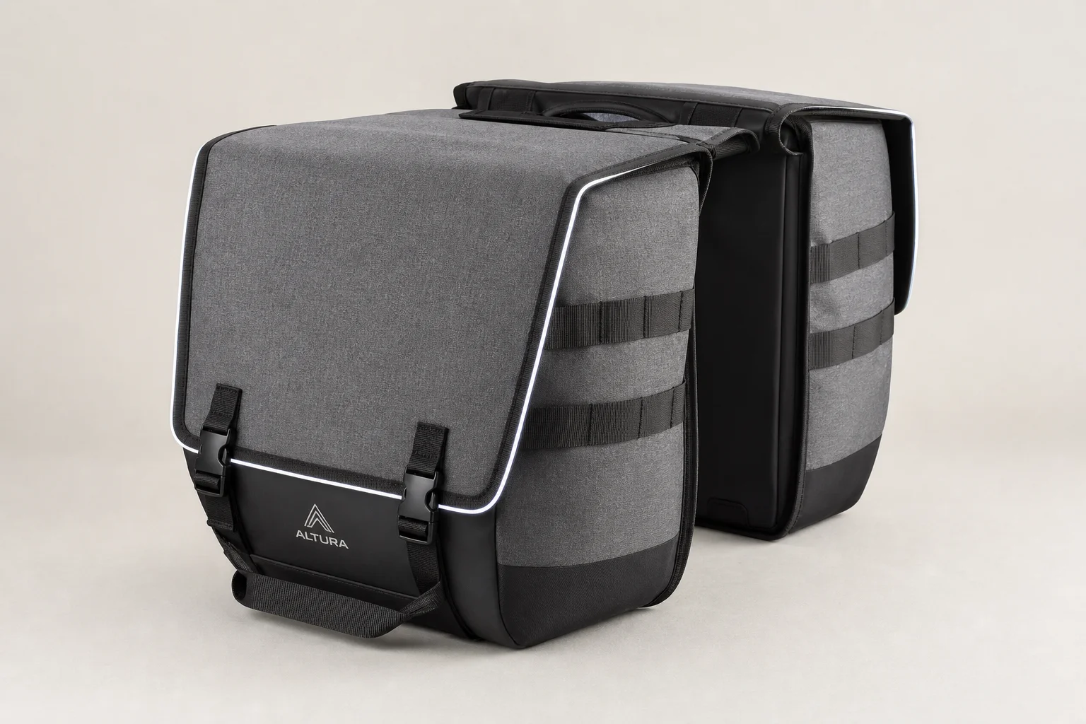 Five bike pannier bags in different styles and sizes arranged on concrete