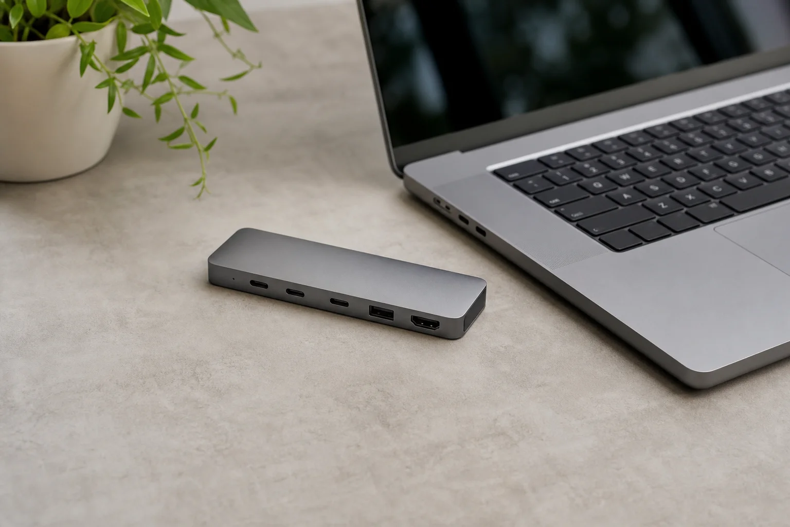 Compact docking hub next to a laptop showing size comparison