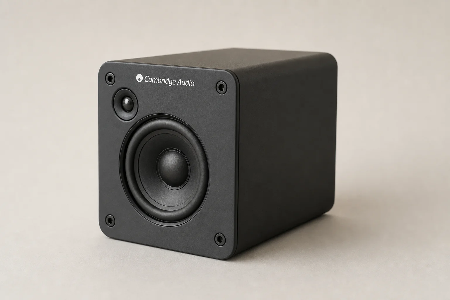 Six bookshelf speakers in varying sizes and finishes arranged on concrete surface