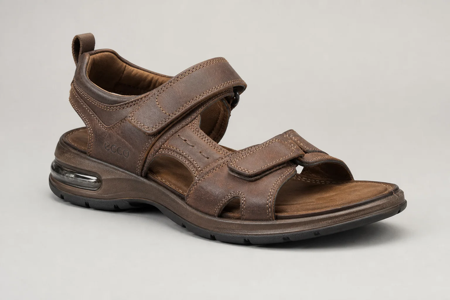 Five hiking sandals arranged on concrete surface representing different styles and protection levels