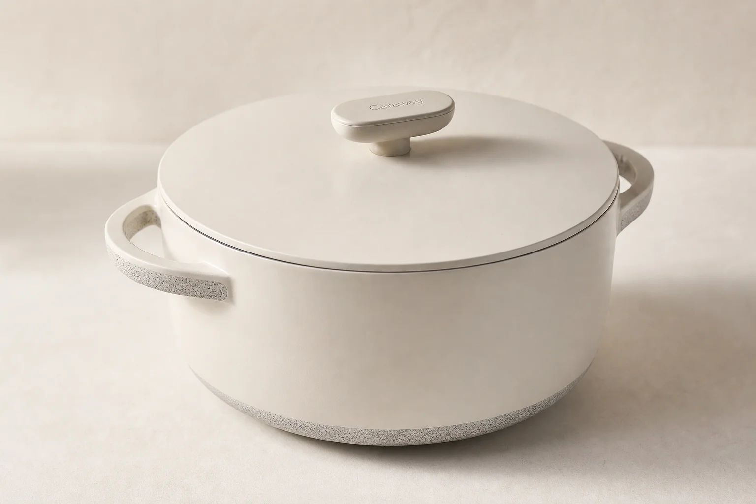 Collection of nine Dutch ovens in various colors and finishes arranged on neutral backdrop
