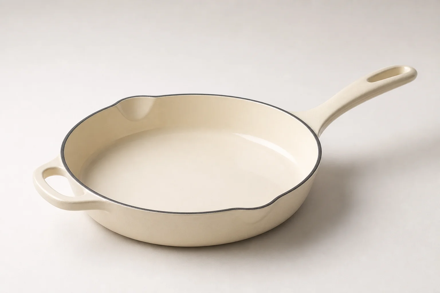 Five cast iron skillets arranged on wooden surface showing variety of styles and finishes