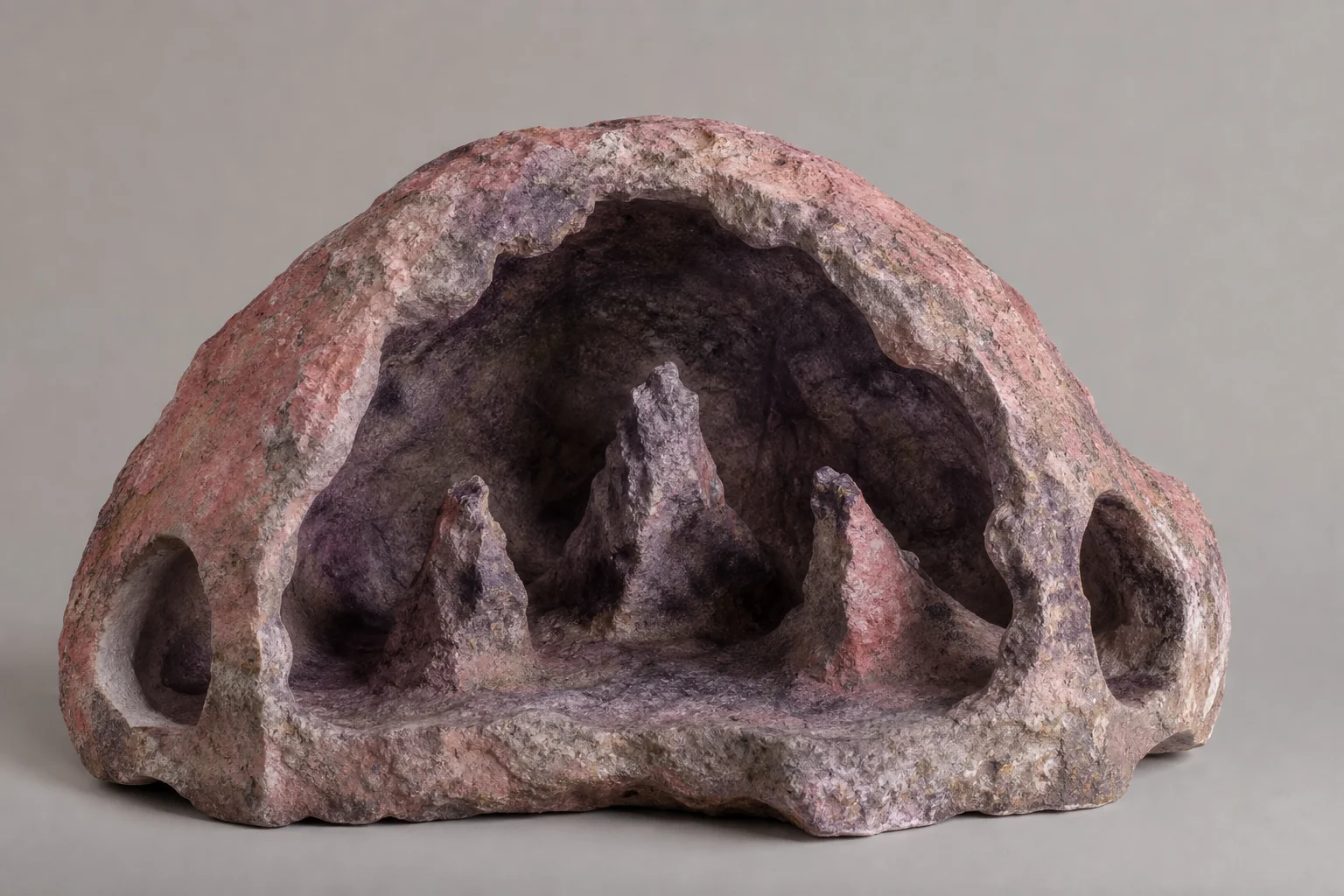 Dome-shaped cave rock positioned to show interior cavernous valley and side entrances
