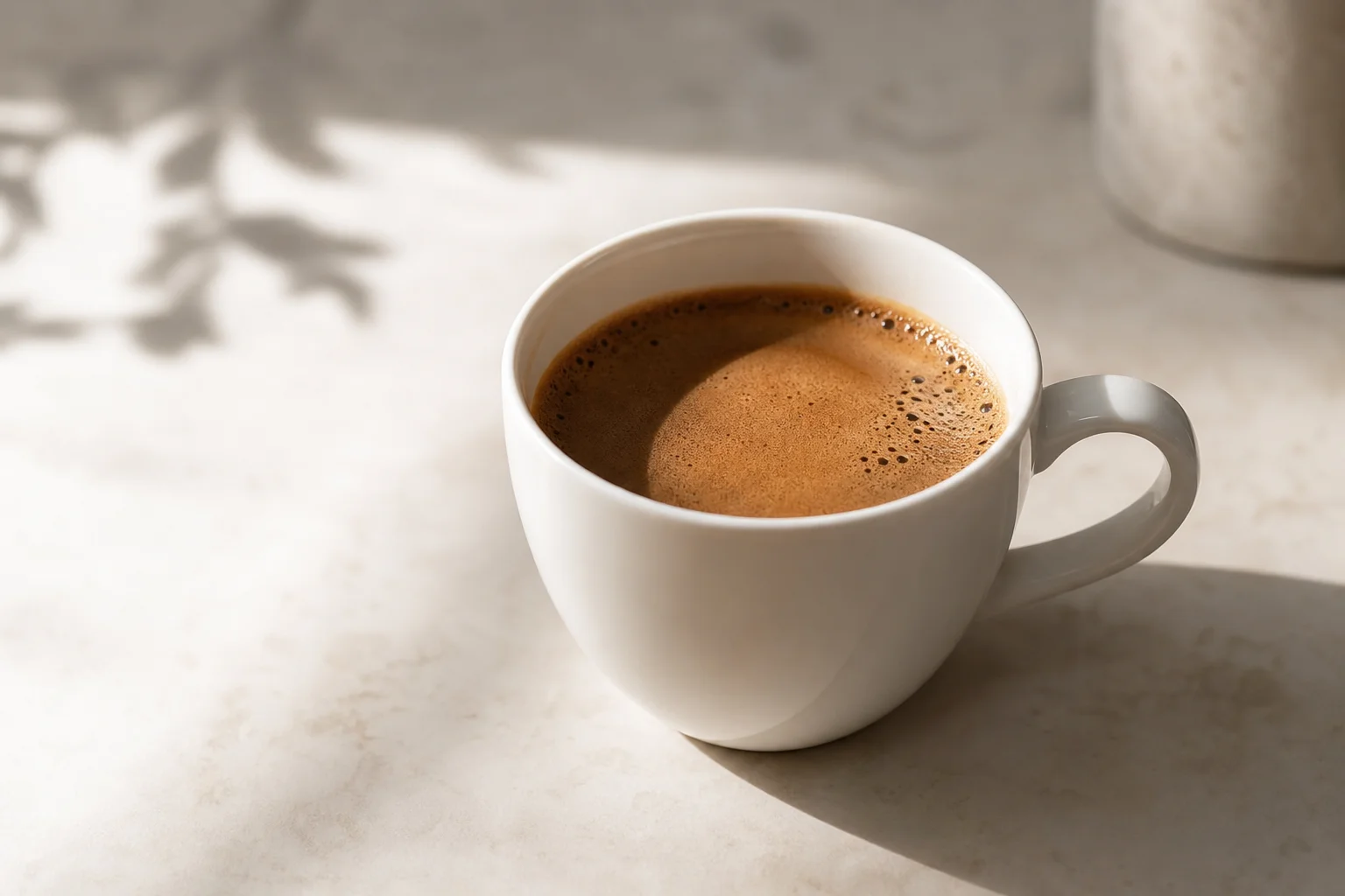 Cup of brewed coffee with rich amber color in morning light