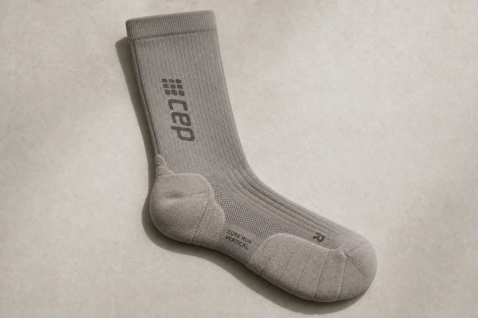 Collection of running socks in various colors and styles arranged on concrete surface