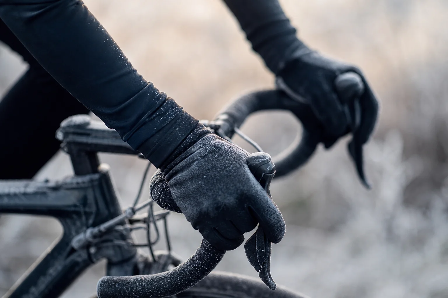 Cyclist's gloved hands gripping handlebars on cold morning ride