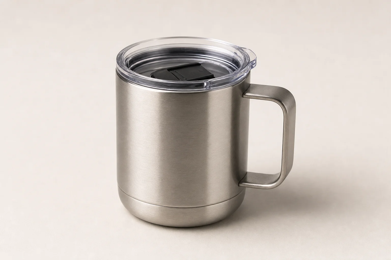 Four non-toxic coffee mugs in glass, ceramic, and stainless steel arranged on concrete