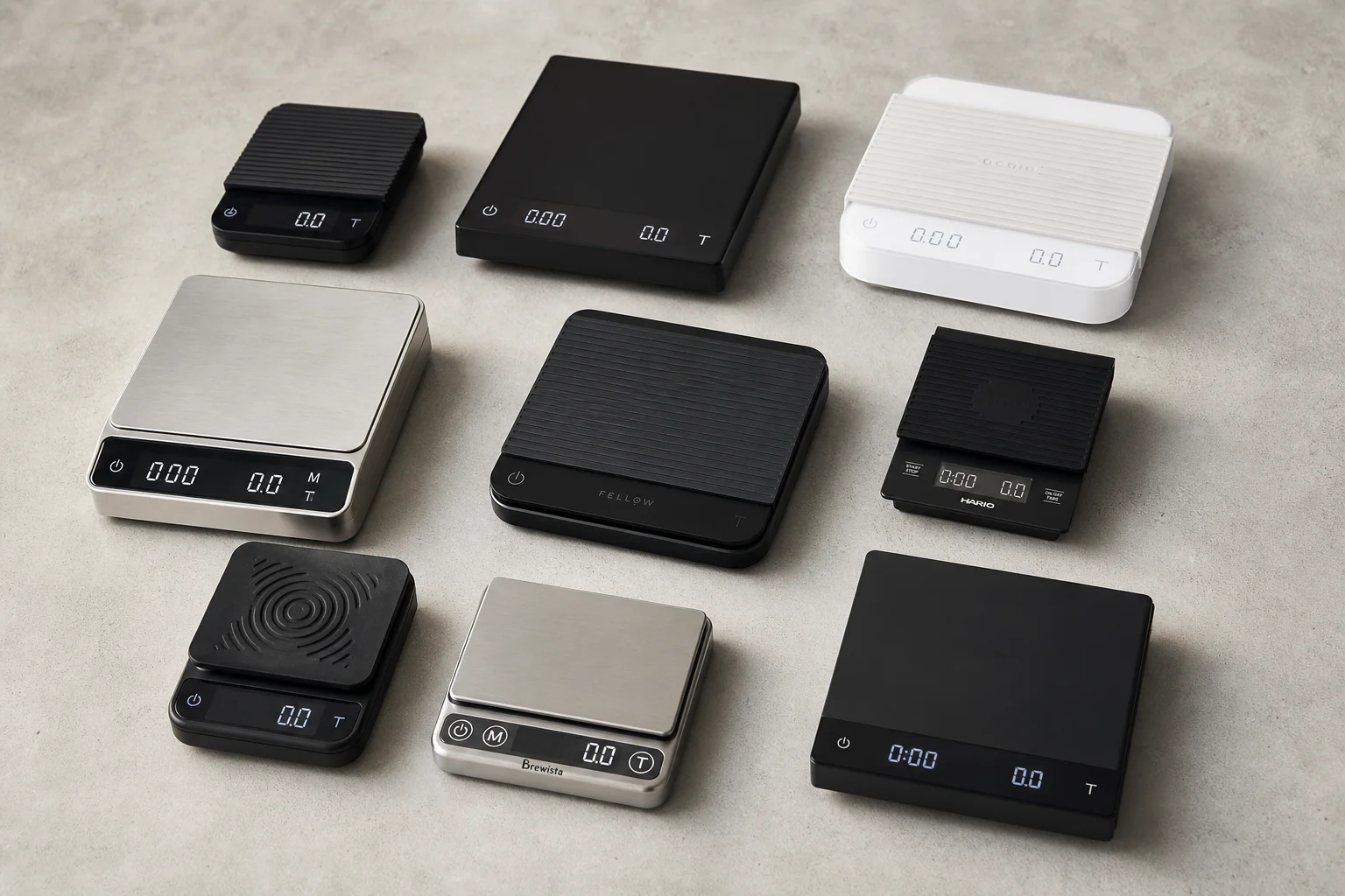 Collection of coffee scales in various sizes and finishes arranged on concrete
