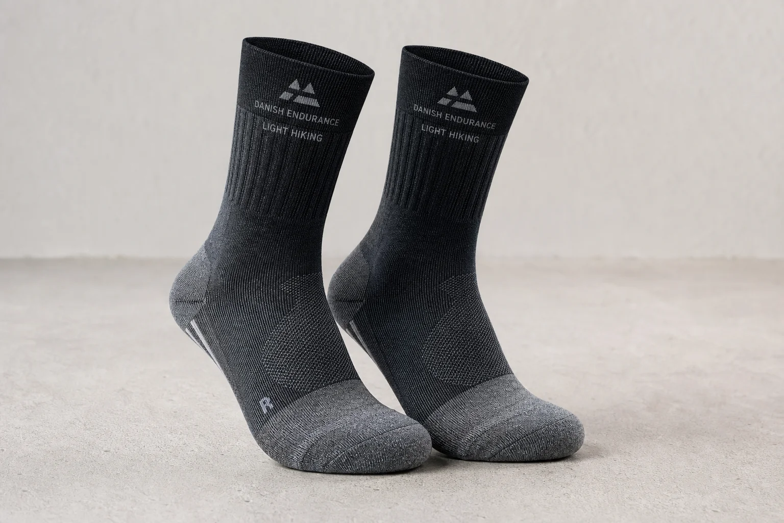 Five pairs of hiking socks in different styles and colors arranged on concrete