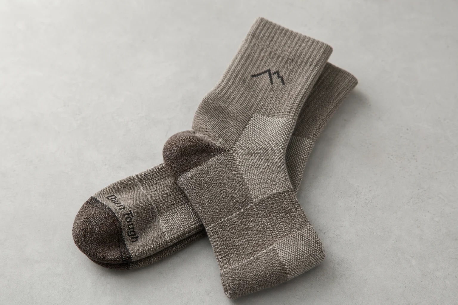 Collection of hiking socks in various styles and materials on neutral backdrop