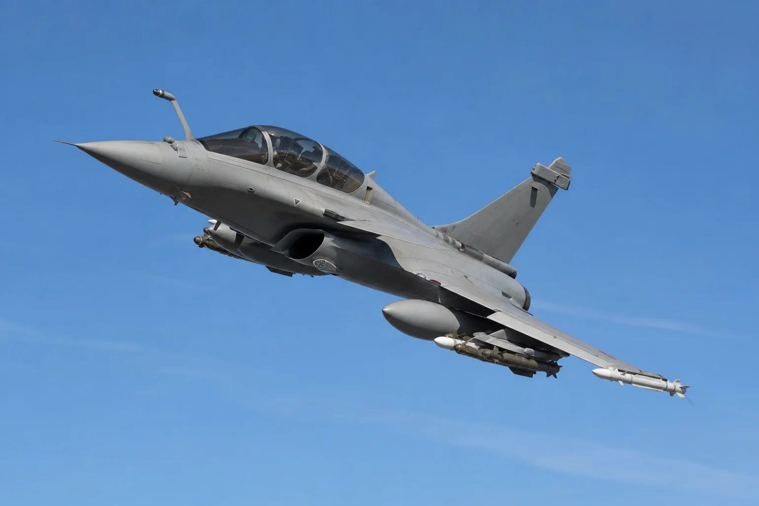 Modern fighter jet in flight against clear blue sky