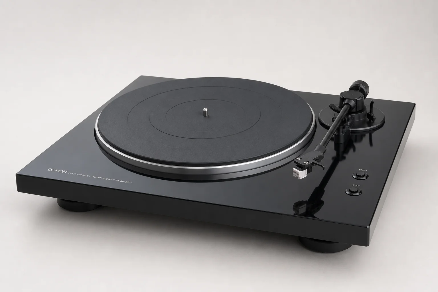 Five vinyl turntables arranged by price tier on concrete surface
