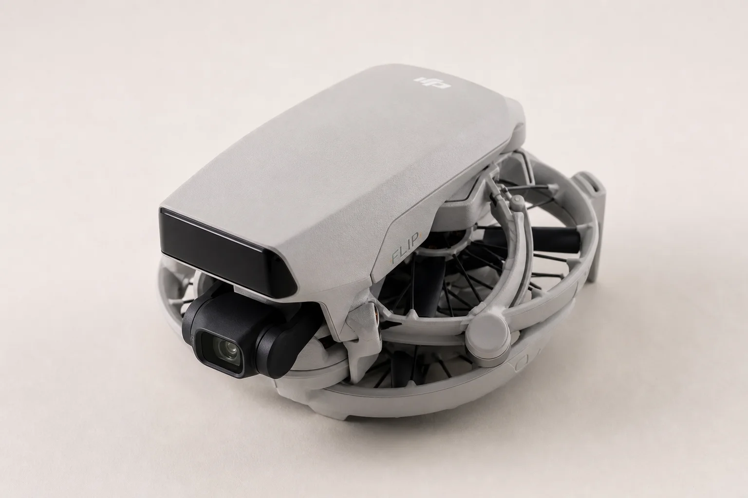 DJI Flip drone folded with propeller guards on neutral grey backdrop