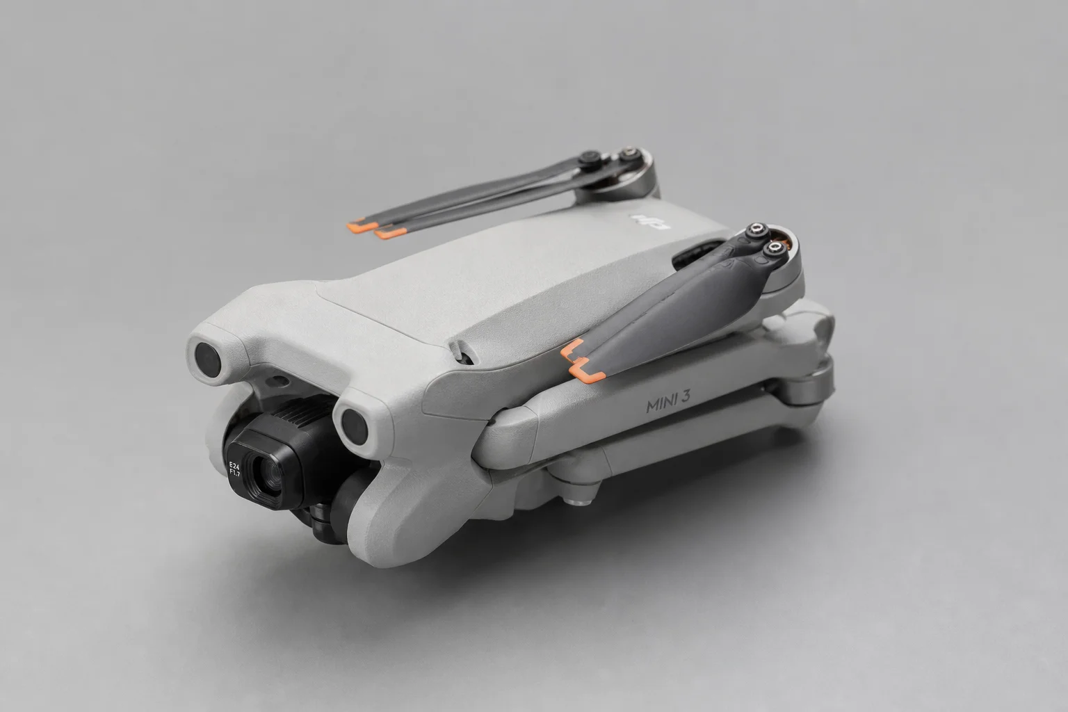 DJI Mini 3 drone in folded position on neutral grey background