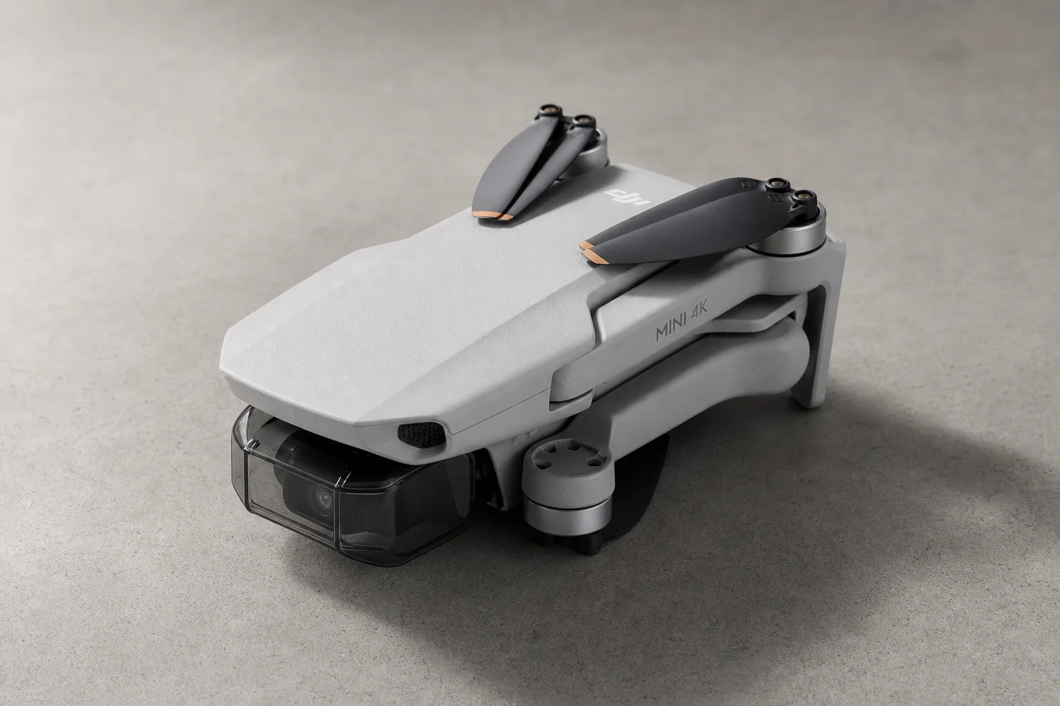 DJI Mini 4K drone with folded arms on neutral concrete surface