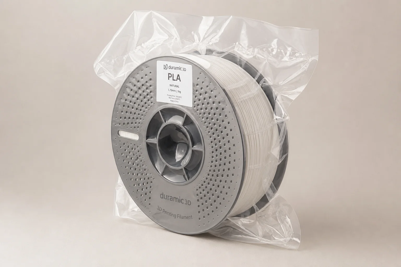 Cinq bobines de filament PLA colorées disposées sur une surface en béton