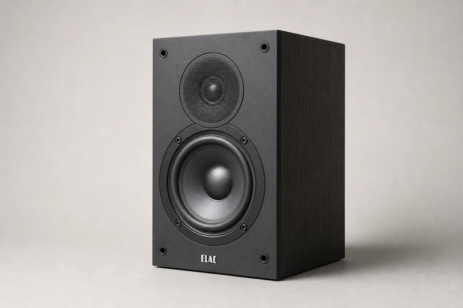 Six bookshelf speakers in varying sizes and finishes arranged on concrete surface