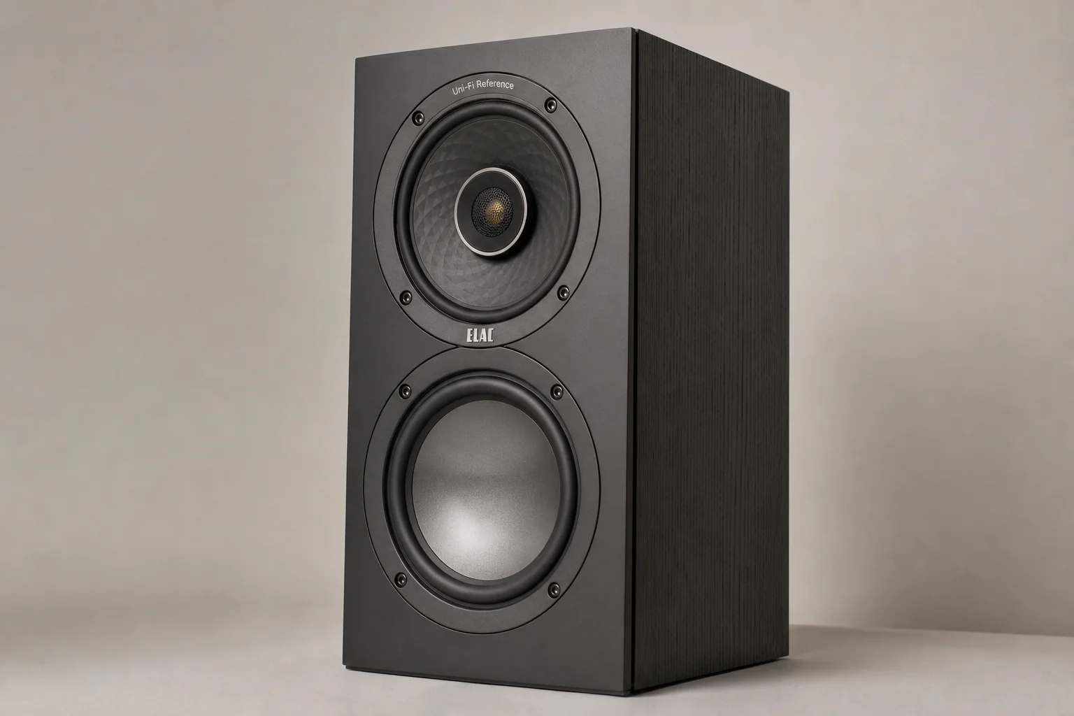 Six bookshelf speakers in various finishes arranged on concrete surface