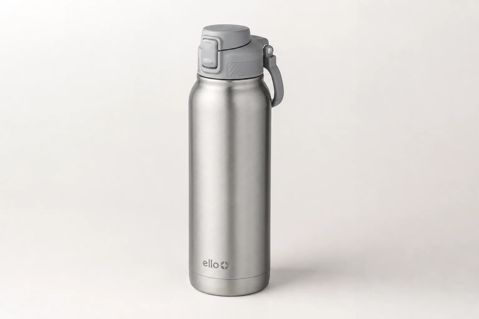 Collection of ten insulated bottles and travel mugs displayed on concrete surface