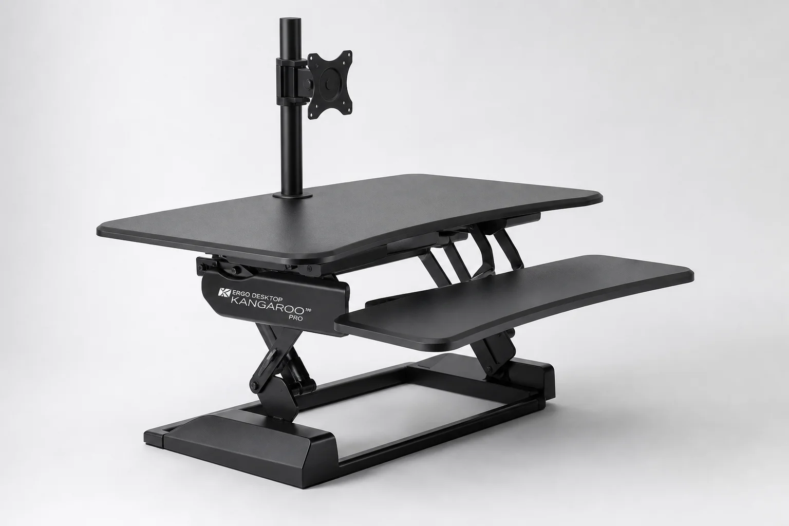 Three standing desk converters displayed on a light wood desk surface