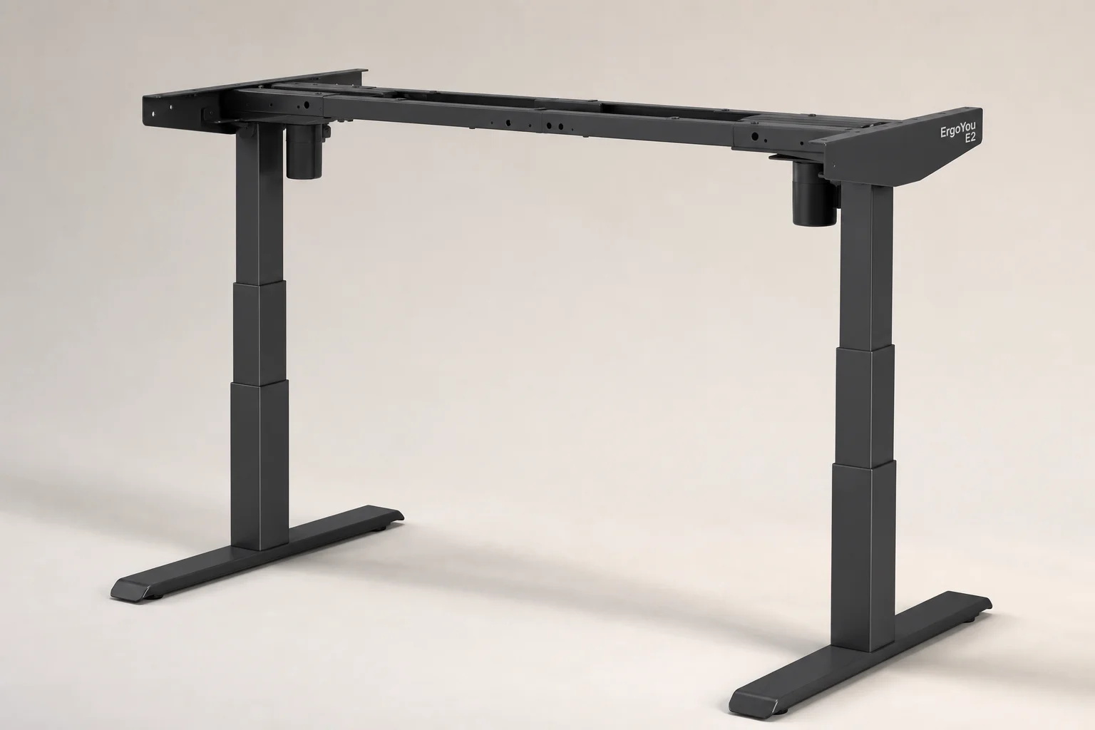 Modern standing desk in raised position with laptop and monitor in bright home office