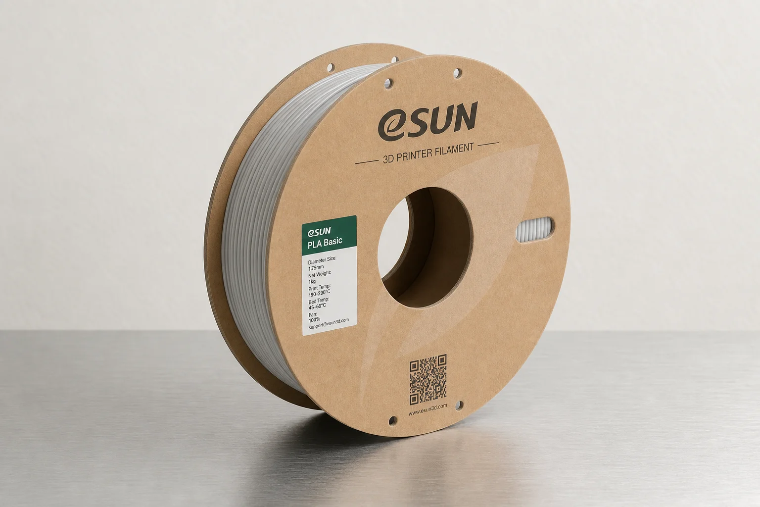 Cinq bobines de filament PLA colorées disposées sur une surface en béton