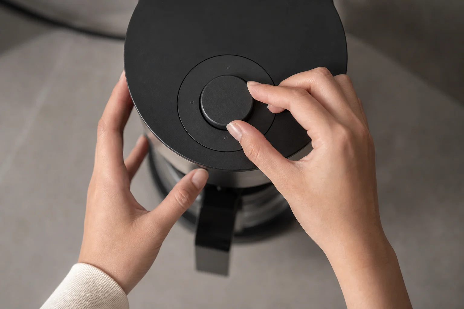 Hands adjusting a circular click wheel interface on a coffee machine
