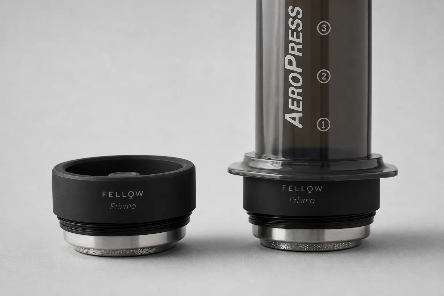Fellow Prismo and Cafflano Kompresso manual espresso makers on concrete surface
