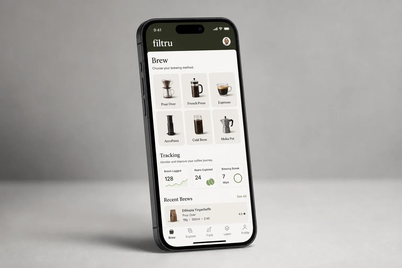 Smartphone with coffee app displayed next to pour-over dripper and coffee beans on concrete