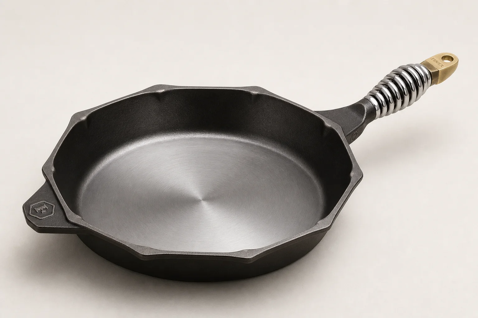 Five cast iron skillets arranged on wooden surface showing variety of styles and finishes