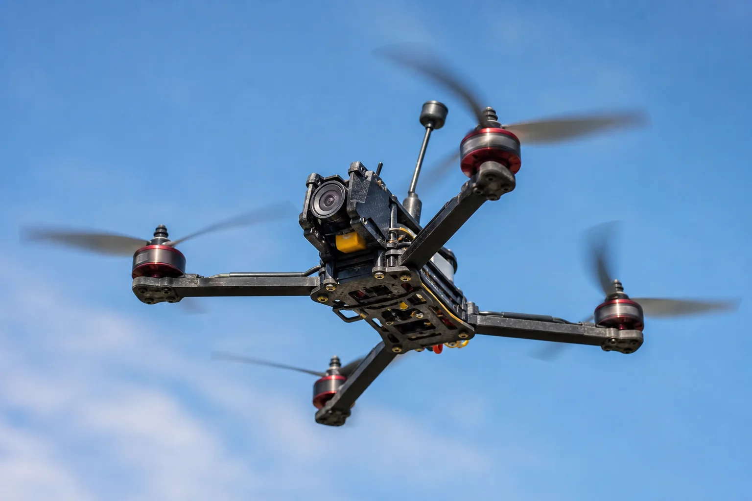 FPV 競速無人機在藍天中飛行，呈現出動態模糊效果