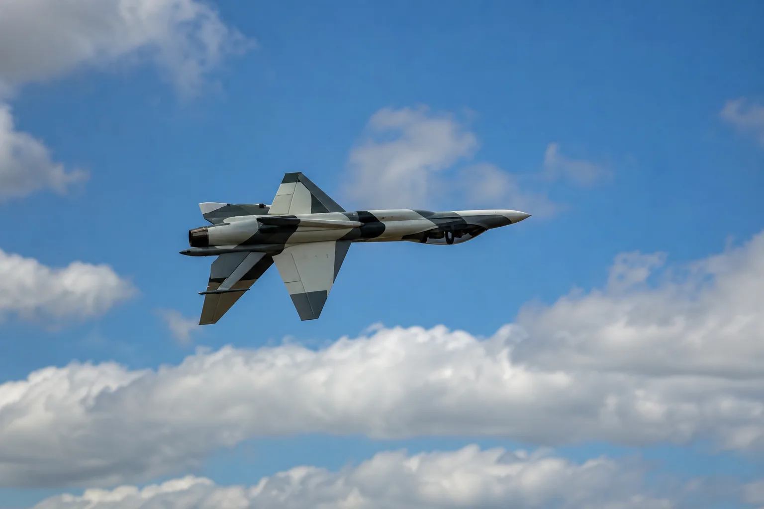 RC jet performing inverted roll maneuver against blue sky with clouds