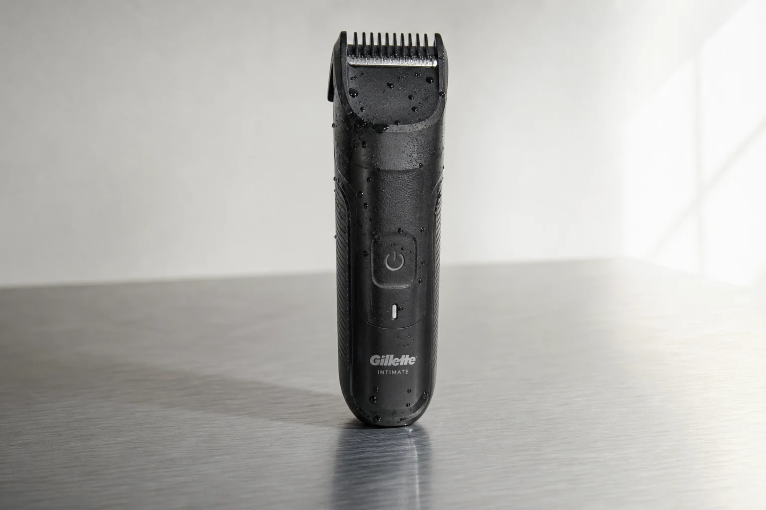 Six pubic hair trimmers arranged on grey surface showing various designs and attachments