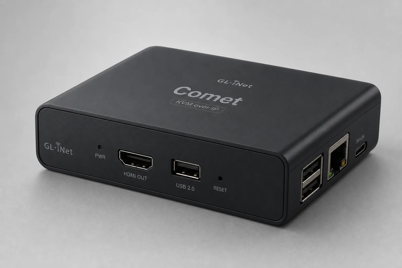 Three GL.iNet Comet KVM devices arranged on concrete surface