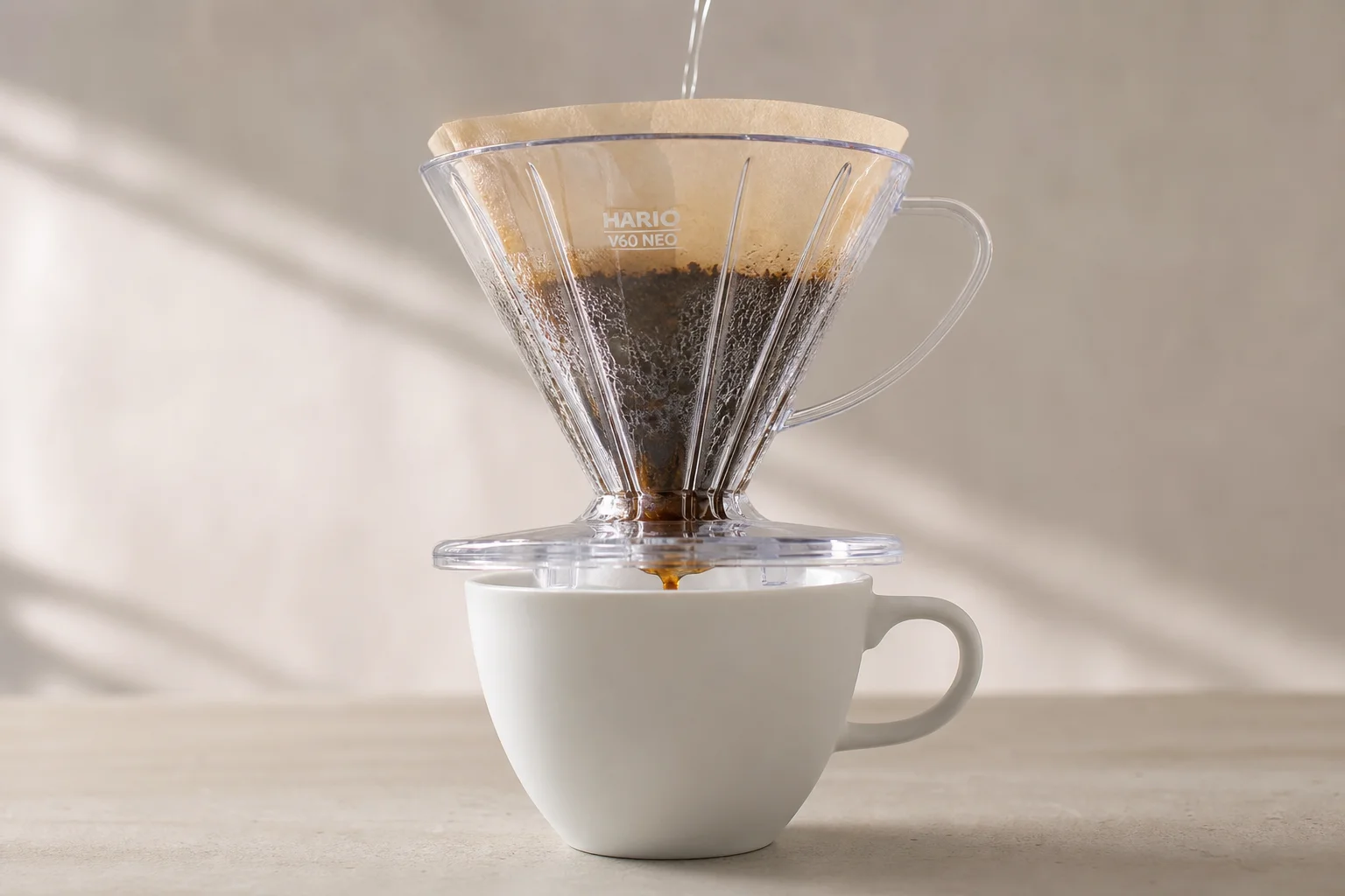Coffee brewing in progress showing water flowing through the V60 dripper into a cup