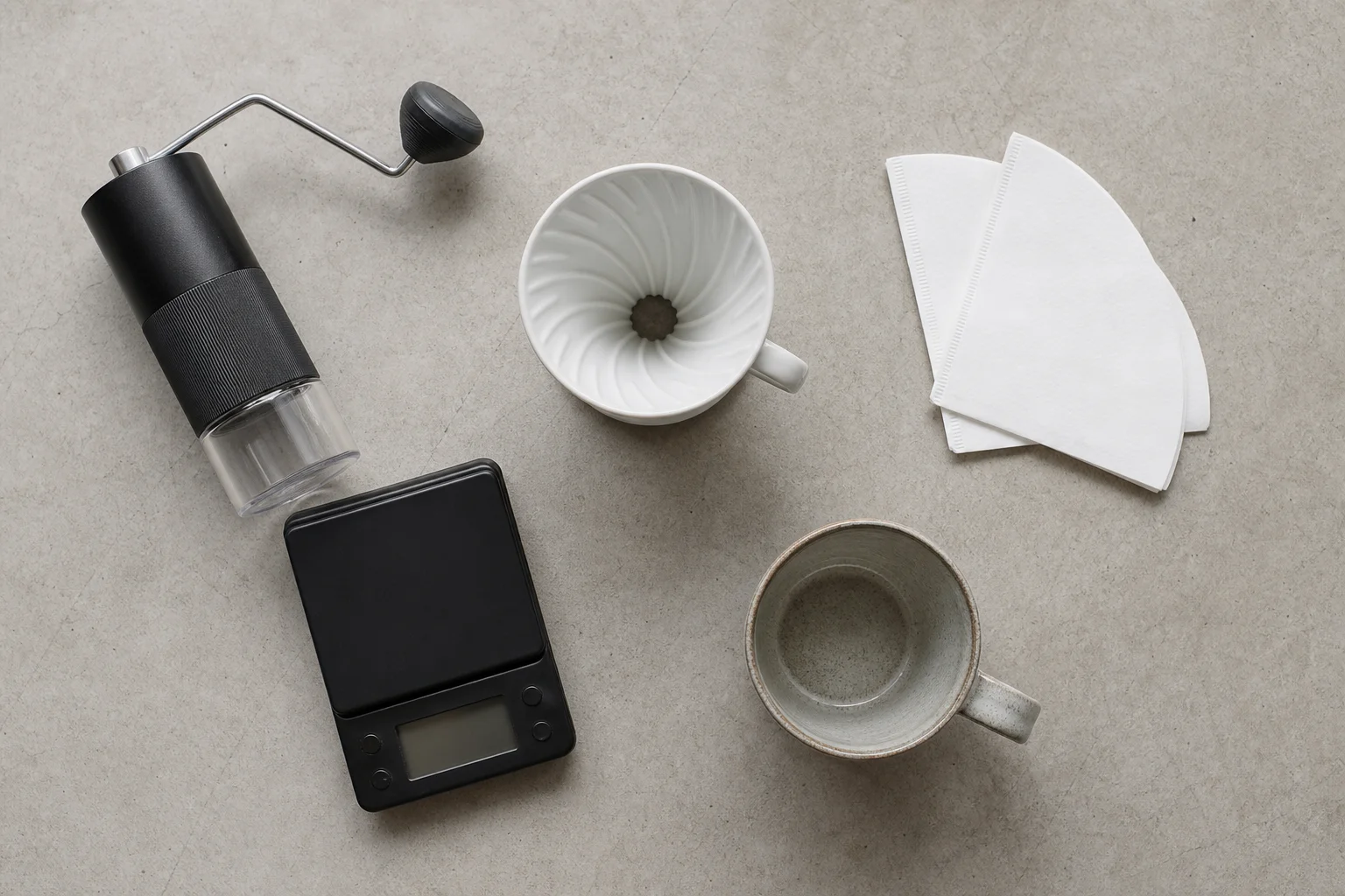 Flat-lay arrangement of coffee brewing equipment including grinder, scale, and V60 dripper
