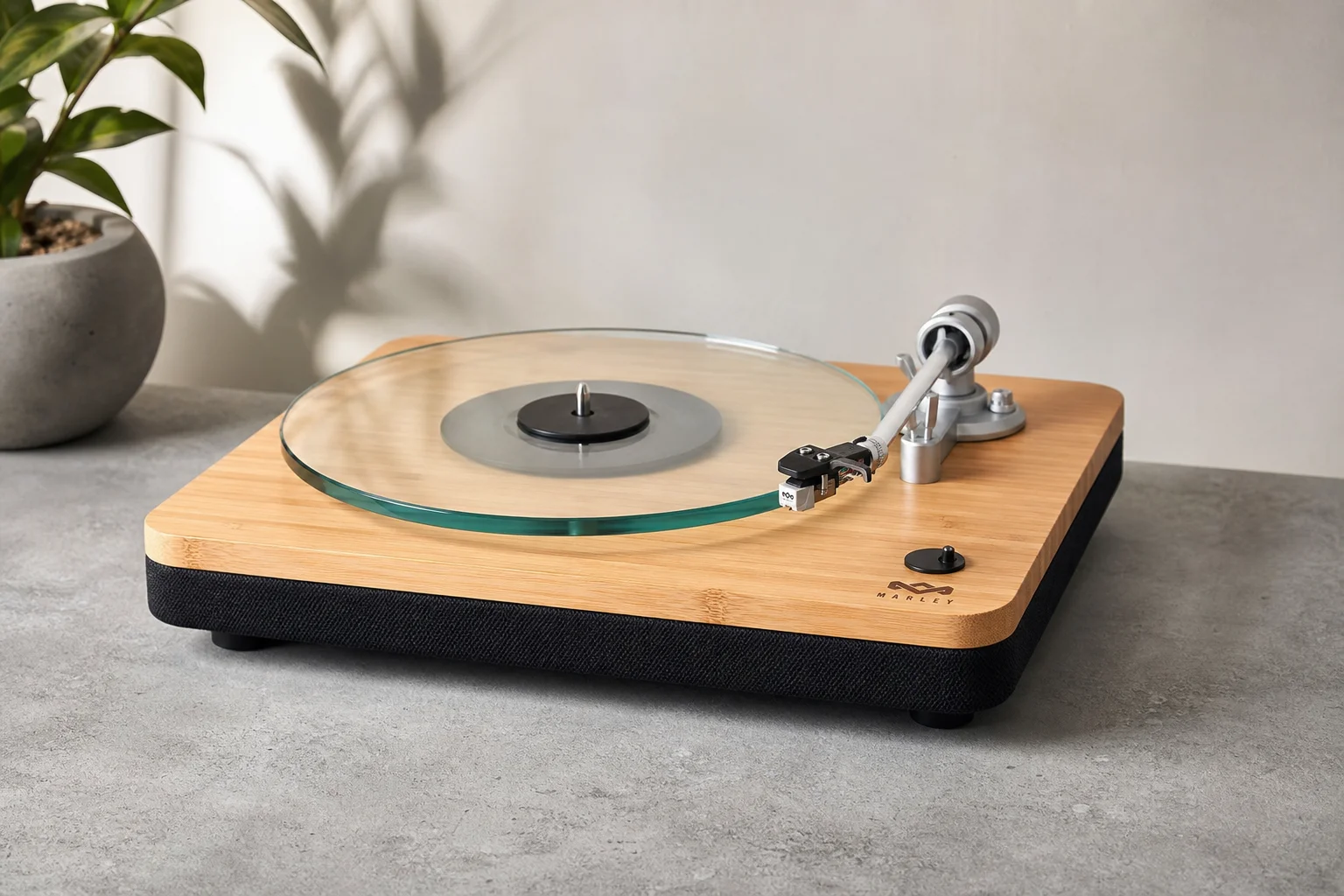 Five vinyl turntables arranged by price tier on concrete surface