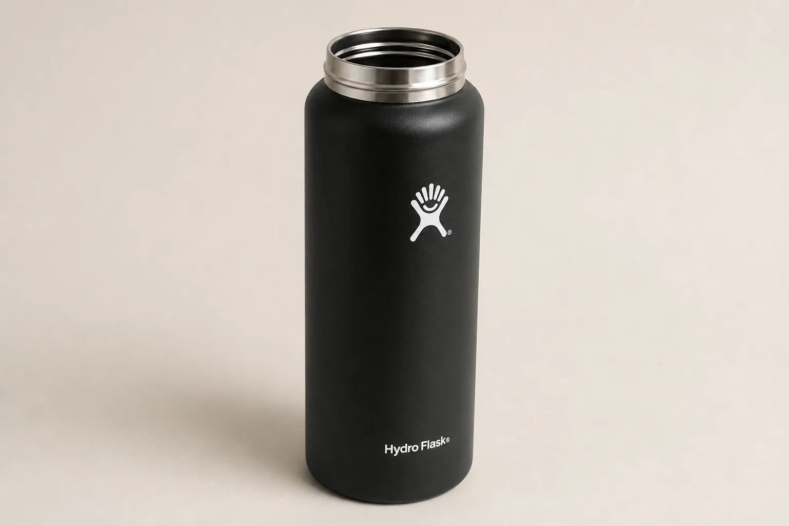 Collection of ten insulated bottles and travel mugs displayed on concrete surface