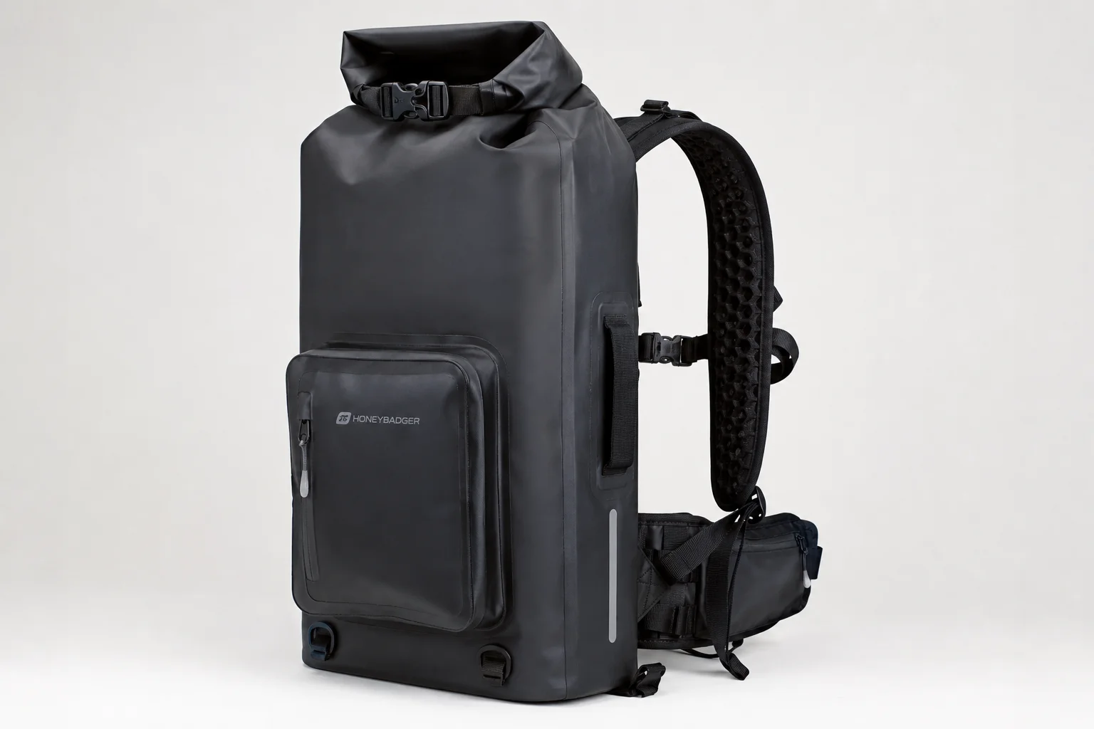Five waterproof dry bags in various sizes and colors arranged on concrete