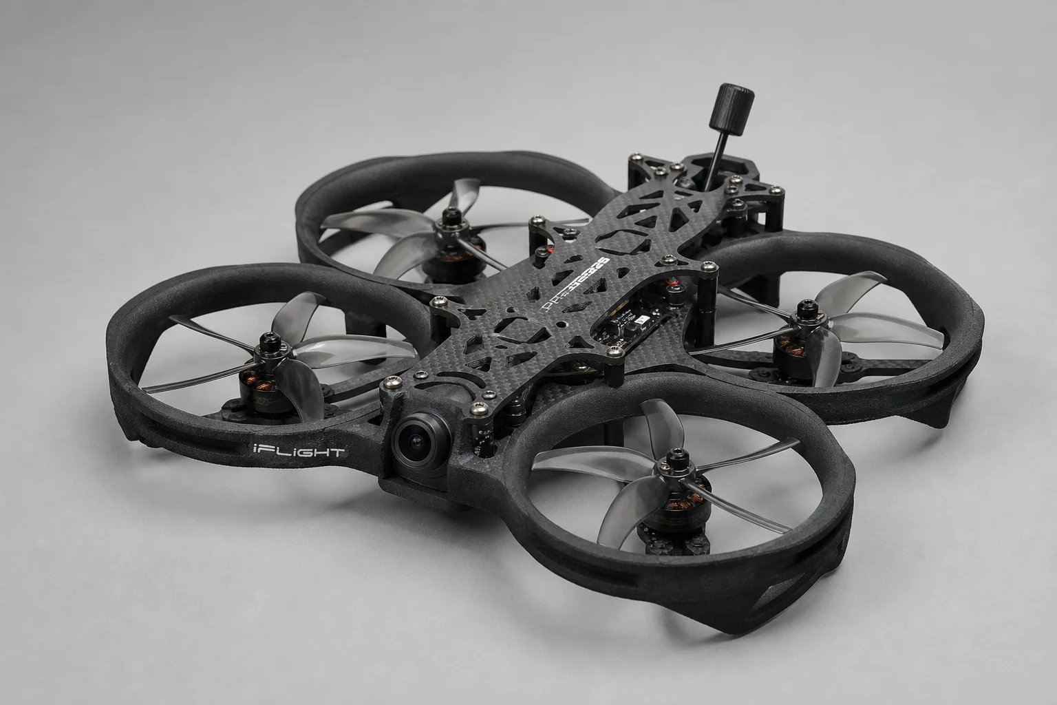 三台小型 FPV 無人機與運動相機放置在水泥地面上