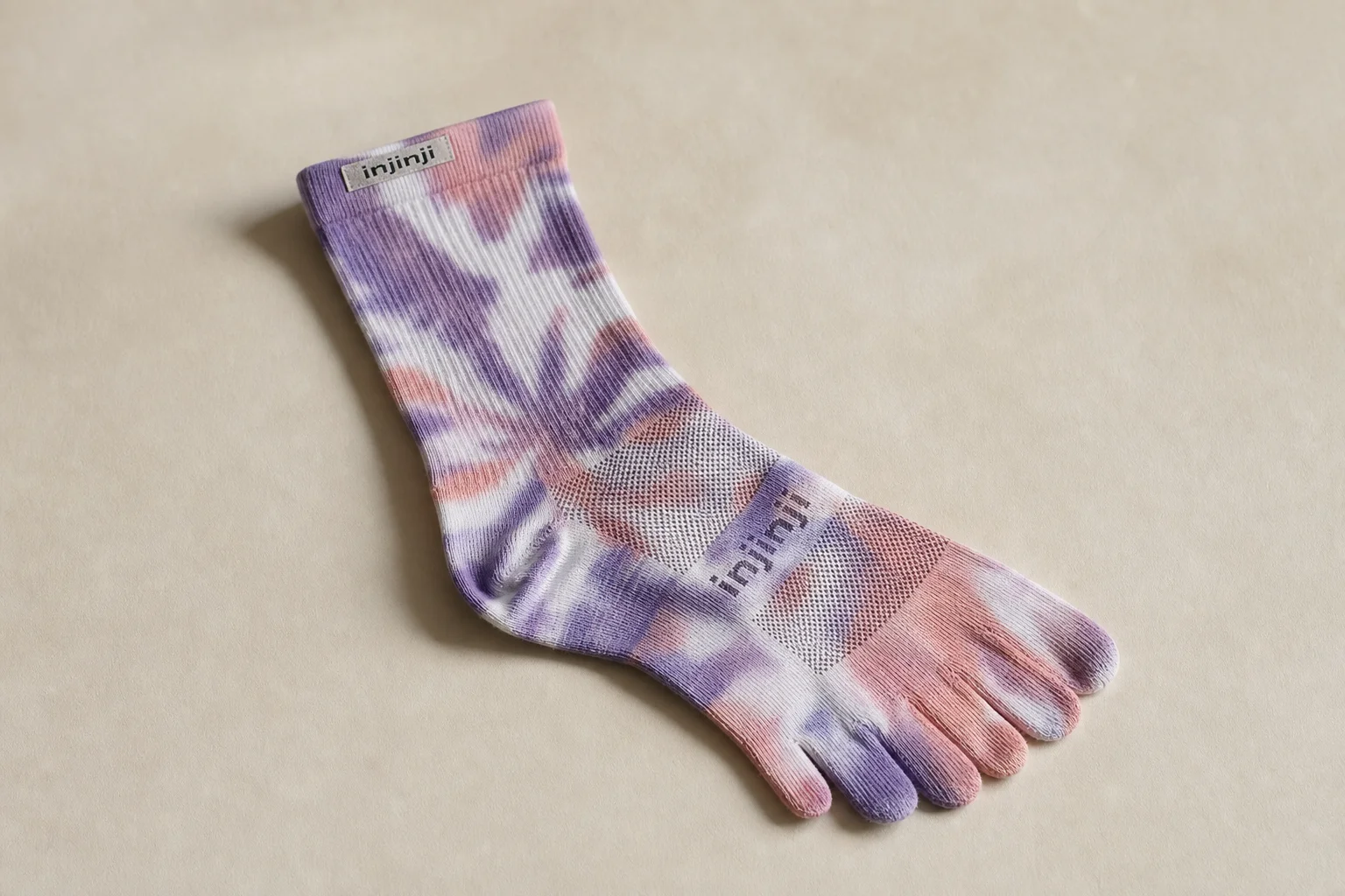 Collection of running socks in various colors and styles arranged on concrete surface