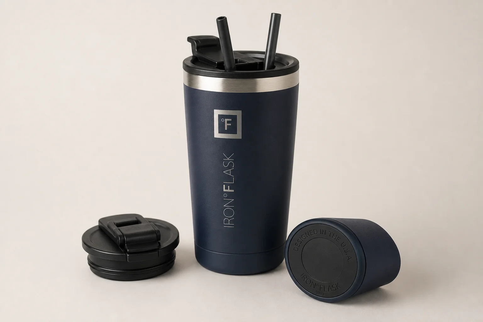 Five travel mugs arranged in ranking order on a concrete surface