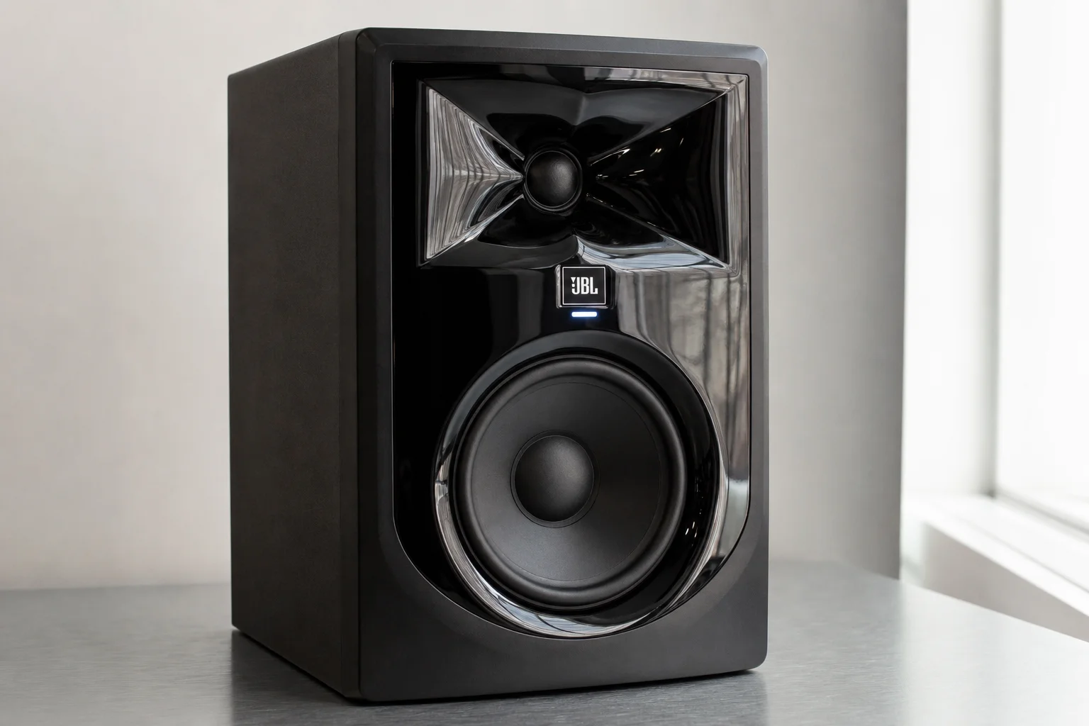 Five studio monitors arranged on concrete surface showing different sizes and designs