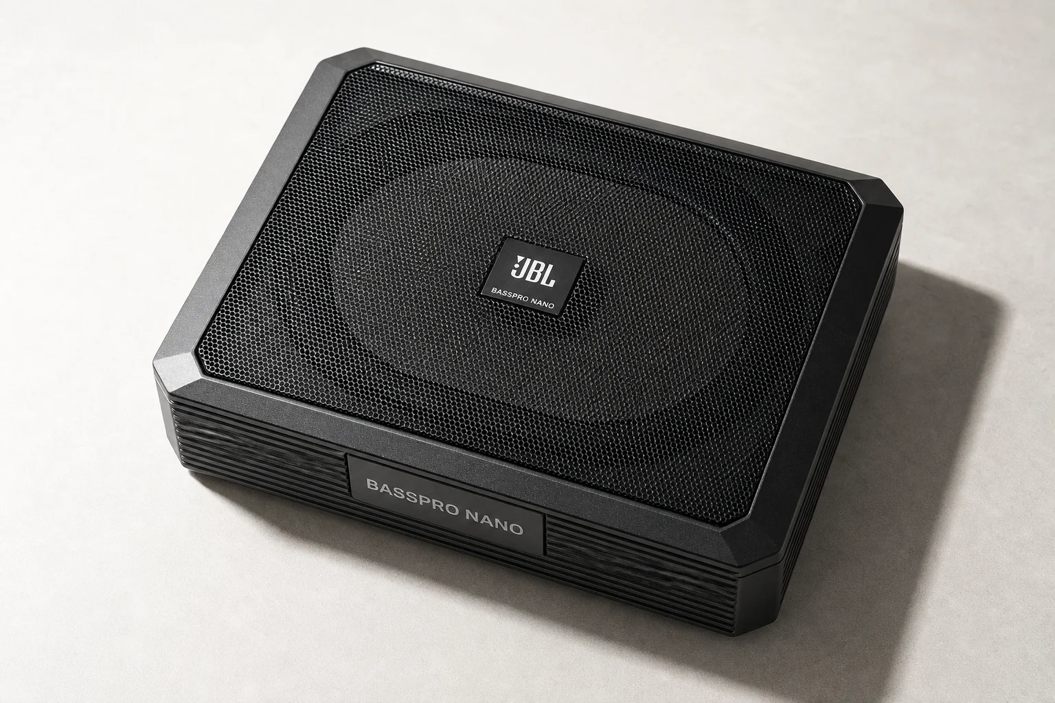 Seven car powered subwoofers of varying sizes arranged on grey surface